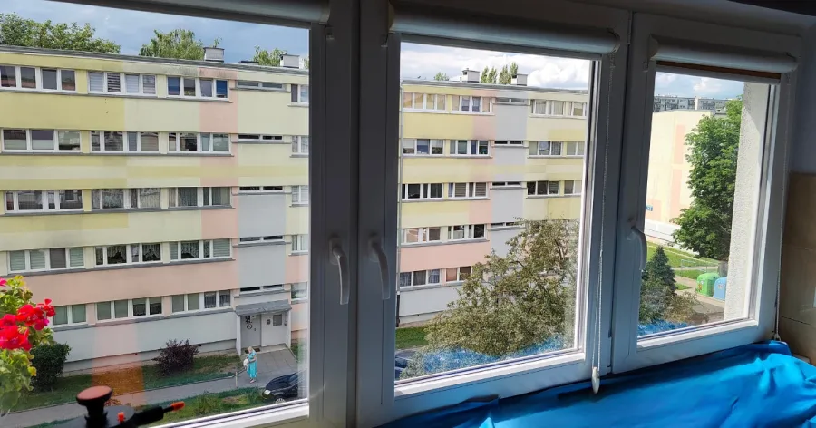 Trzy okna w mieszkaniu z dyskretną przezroczystą folią przeciwsłoneczną na szybach