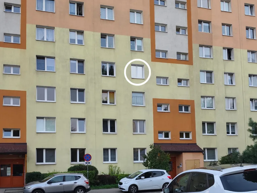Okno w bloku mieszkalnym z folią przeciwsłoneczną, widoczny efekt lustra z zewnątrz