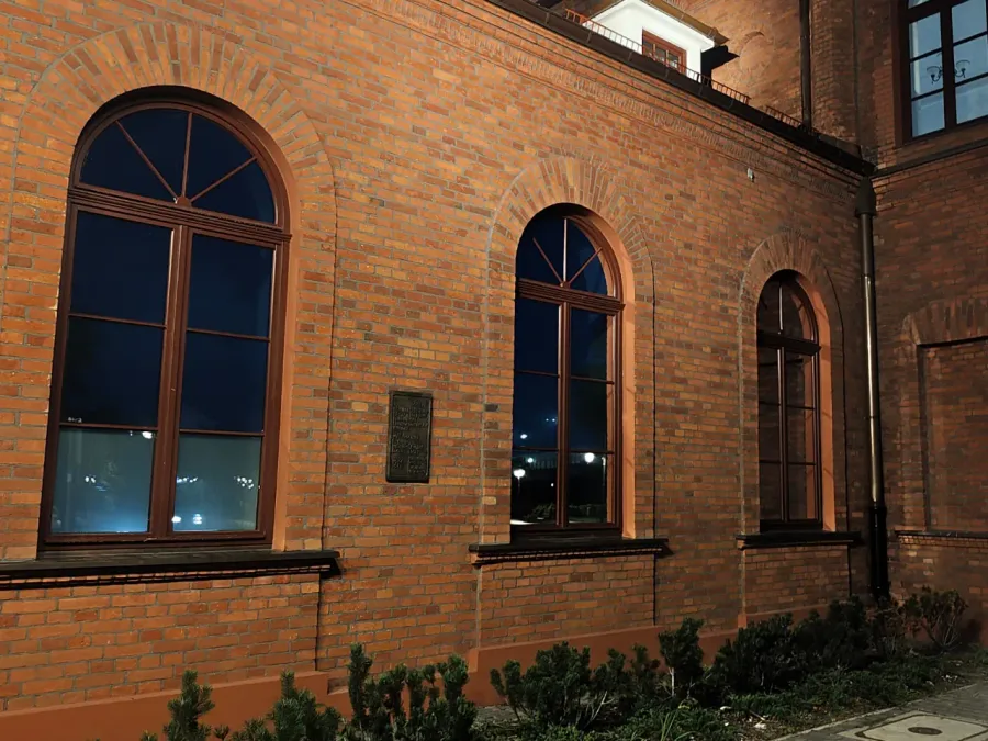 Zabytkowy budynek z folią lustrzaną na oknach, widok nocny