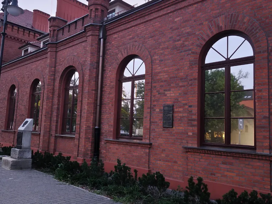 Ceglany, zabytkowy budynek z folią o efekcie lustra na oknach, widok o zmierzchu